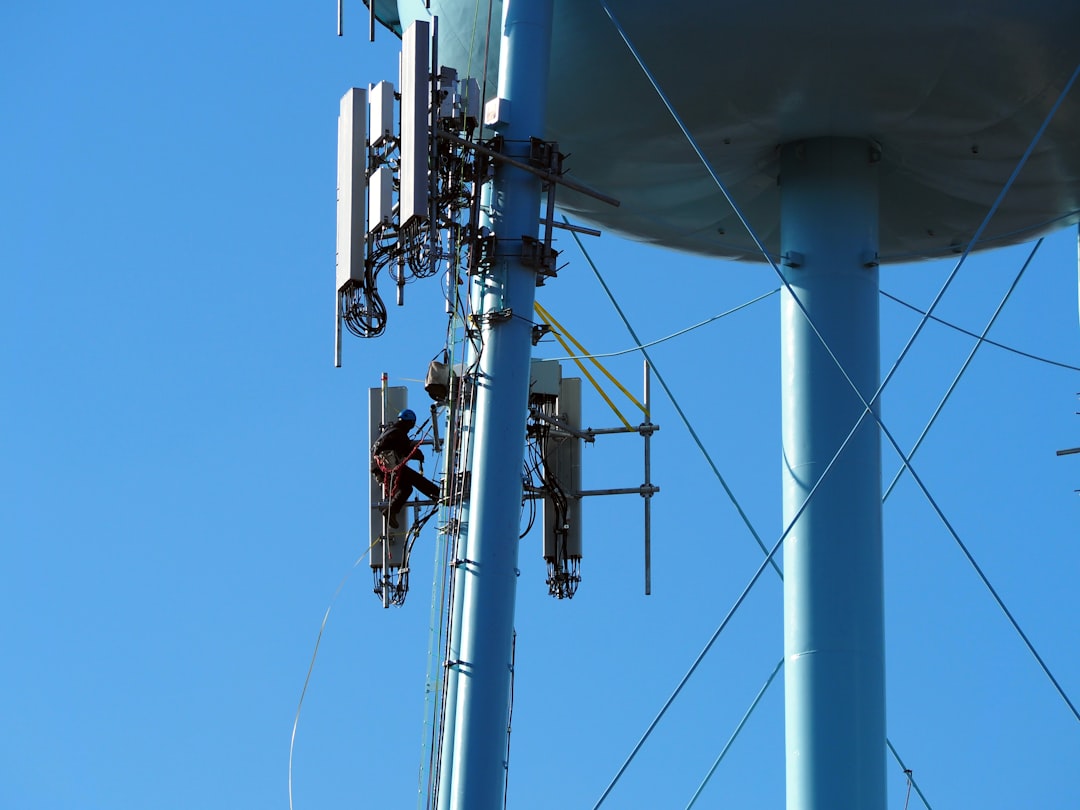 services-03 A maintenance worker, dozens of feet above the ground, works on cell phone antennas attached to the legs of a water tower in Sanatoga PA during January 2025.