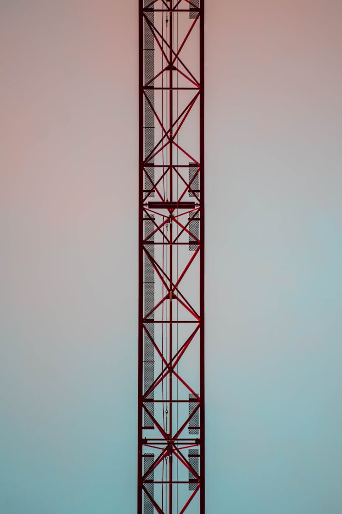 about-01 Vertical shot of a tall steel construction tower against a gradient sky.